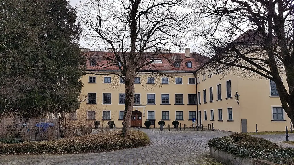 Schloss Ismaning mit Bäumen und gepflastertem Vorplatz, heute Rathaus der Gemeinde