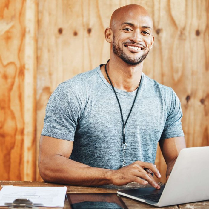 Laptop, portrait and coach with man in gym for fitness instructor, planning and digital membership record. Online schedule, personal trainer and equipment manager with person in health facility.