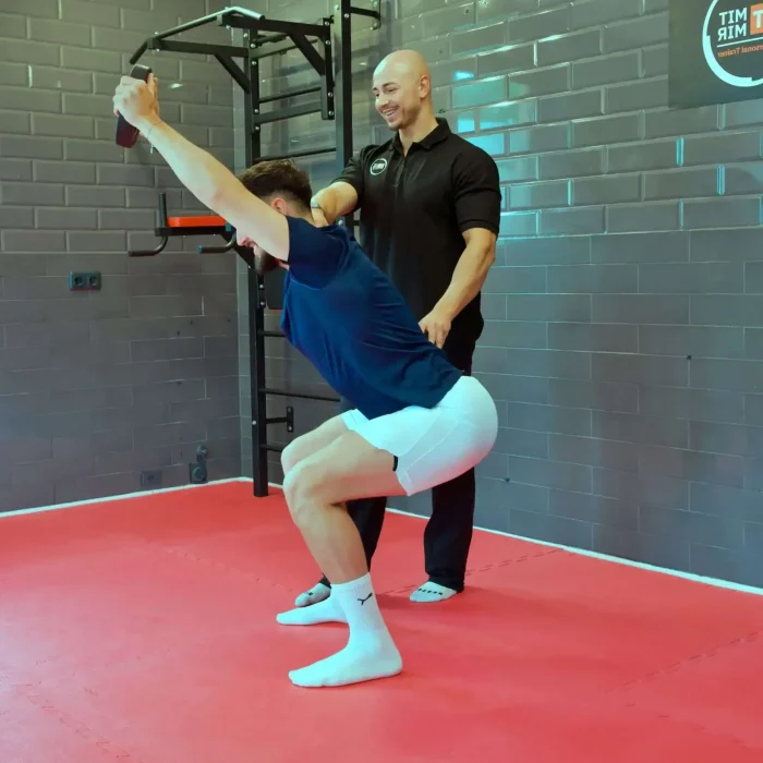 Personal Trainer in Freising Nabil Kayali unterstützt einen Klienten bei Kniebeugen Professionelles Personal Training Studio für individuelle Fitnessziele